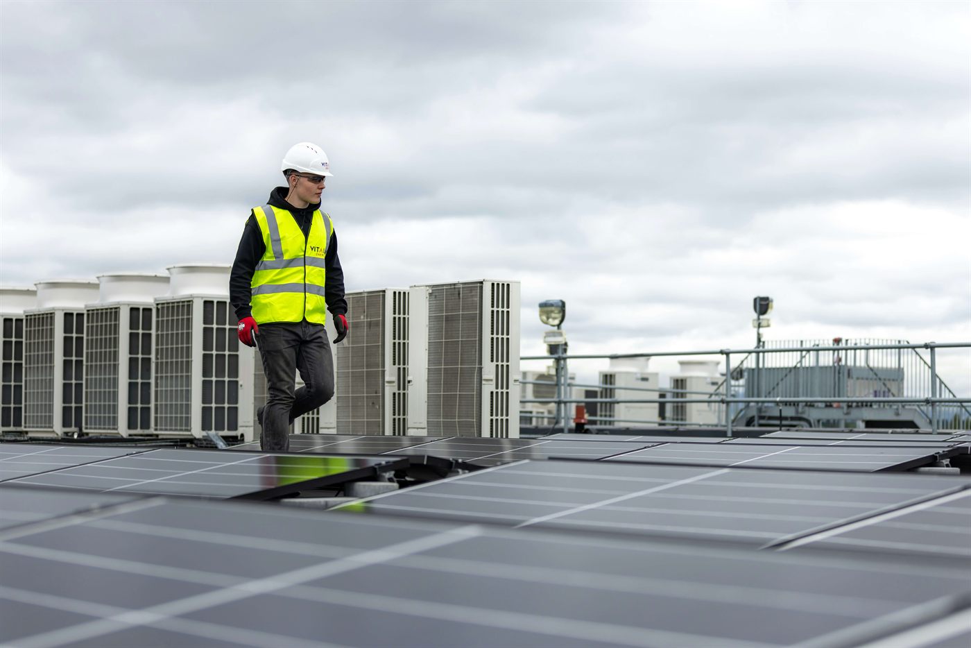 HVAC technician walking near rooftop units
