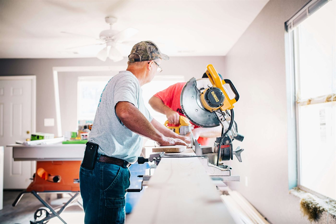 Remodeling crew cutting wood inside a home