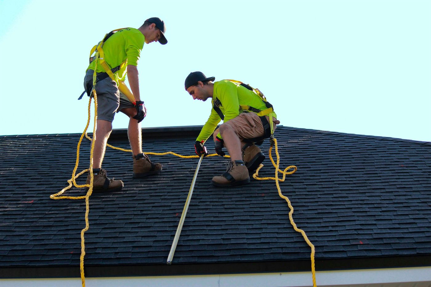 Roofing crew measuring a roof